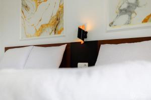 1 dormitorio con 1 cama con lámpara y 2 fotografías en SG Hotel Pangandaran, en Pangandaran