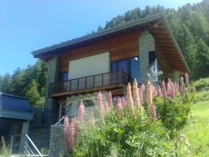 a house with a bunch of flowers in front of it at La Niche B&B in La Thuile