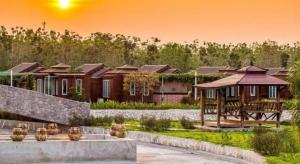 Ban Phan Sadet NaiPrew Lom Chom Nam Resort的夕阳西下时，院子里的一组房屋