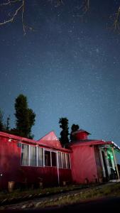 カナタルにあるBagheecha Homestayの空に星が輝く赤い家