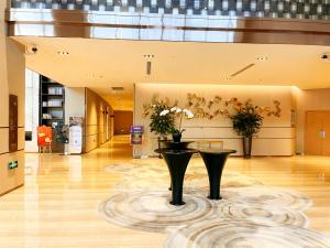un vestíbulo con una mesa y flores en el suelo en HongQiao ZZ-IHome Prime Residence Apartment - National Exhibition Center, en Shanghái
