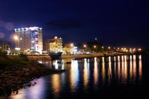 a city at night with lights on a river at Luxe Hotel in Xóm Ðé
