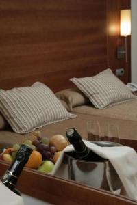 bandeja de fruta y botella de vino en una habitación de hotel en BS Capitulaciones, en Santa Fe