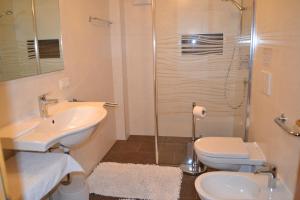 ein Bad mit einem Waschbecken, einem WC und einer Dusche in der Unterkunft Ferienwohnung Pramstaller in Olang