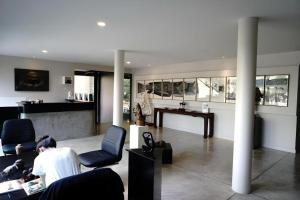 un homme assis dans un salon avec une table et des chaises dans l'établissement Silp-Pa Phra Nakhon Si Ayutthaya Hotel, à Phra Nakhon Si Ayutthaya