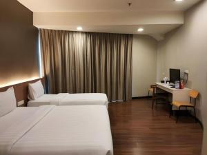 a hotel room with two beds and a desk at Hotel 61 Medan in Medan +156 photos