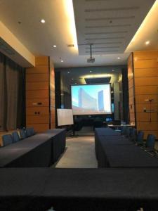 a large room with a projection screen and chairs at Oak Chateau in Jinzhou