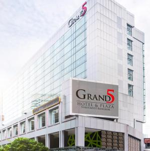 a tall white building with a sign on it at Grand 5 Hotel & Plaza Sukhumvit Bangkok in Bangkok