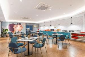a restaurant with tables and chairs and a kitchen at Magnotel Shanghai Henglong Plaza in Shanghai
