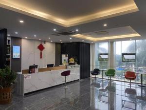 a lobby with a counter with stools in front of it at GreenTree Inn Shenzhen Guanggang Port Futian South Road Express Hotel in Hong Kong
