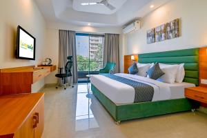 a hotel room with a bed and a television at Limewood Signature - Golf Course Road in Gurgaon