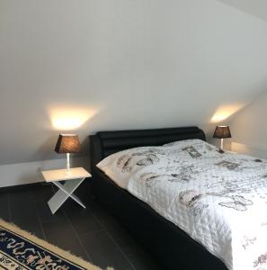 a bedroom with a bed and a table with lamps at Haus Kummer in Selm