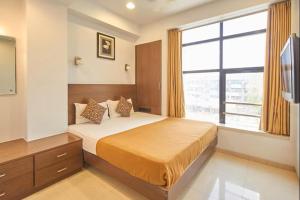 a bedroom with a bed and a large window at The Sapphire Hotel in Nagpur