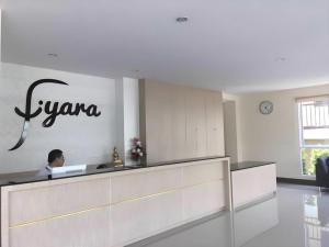 a man sitting at a counter in a lobby at Iyara Hotel Nongkhai in Nong Khai