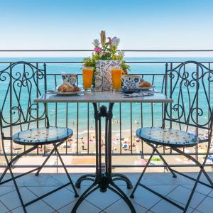 un tavolo con cibo su un balcone con vista sulla spiaggia di B&B Tramonto Sul Mare a Salerno