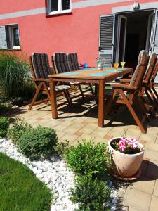 Une table et des chaises en bois sont disponibles sur la terrasse. dans l'établissement Nikka Apartments, à Malinska