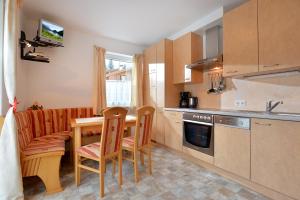 a kitchen with a table and chairs and a couch at Appartement Horngacher in Scheffau am Wilden Kaiser