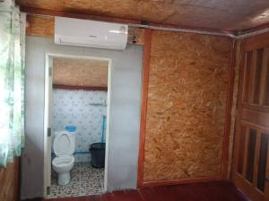 a bathroom with a toilet and a wall at Green moon Home stay room2 in Buriram
