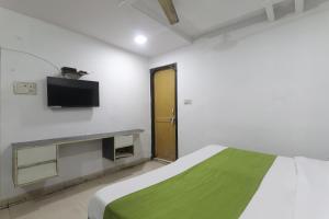 Un dormitorio con una cama y un televisor en una pared. en Hotel Dayal, en Lucknow 26 fotos más