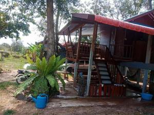 a house with a porch and a tree at Green moon Home stay room2 in Buriram