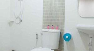 a bathroom with a white toilet and a sink at Bees Smile Hotel in Ban Fang Min