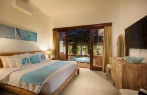 a bedroom with a large bed and a television in it at Villa Lotus Flower Sanur in Sanur +46 photos