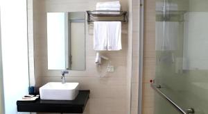 un baño con lavabo y espejo en Shell Ganzhou Central Theme Hotel, en Ganzhou 166 fotos más
