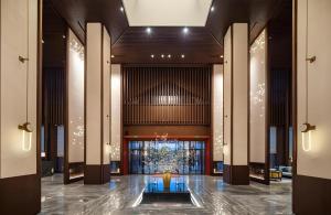 un hall avec un arbre au centre d'un bâtiment dans l'établissement Hampton by Hilton Nanhai Haikou, à Haikou