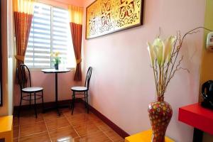 un vase avec des fleurs sur une table dans une pièce dans l'établissement PS Resort, à Ban Kohong