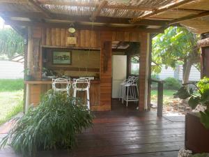 a house with a deck with chairs and a bar at Fare Hinavainui in Orufara
