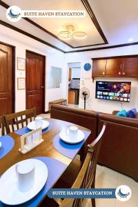 a dining room with a table and chairs and a kitchen at Suite Haven Staycation in Sampong