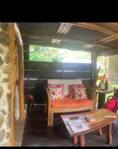 a living room with a couch and a table at Fare Hinavainui in Orufara