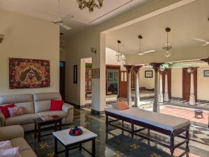 a living room with a couch and a table at Saranyam by LuxUnlock Private Villas in Kāraikkudi