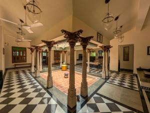 an indoor pool with a checkered floor and chandeliers at Saranyam by LuxUnlock Private Villas in Kāraikkudi