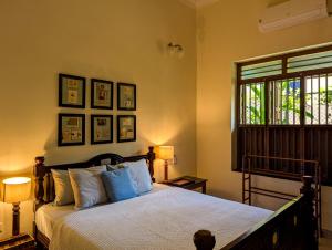 a bedroom with a bed with pillows and a window at Saranyam by LuxUnlock Private Villas in Kāraikkudi