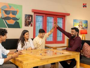 Un grupo de personas sentadas alrededor de una mesa jugando un juego. en Moustache Hostel Bir, en Bīr