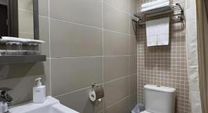 a bathroom with a white toilet and a sink at WE Hotel Kowloon in Hong Kong