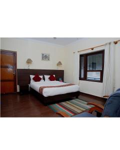 a bedroom with a bed with red pillows and a window at Hotel Lake Place in Pokhara