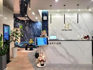 a lobby of a hotel lied with a computer on a counter at Hotel PIED Suseong in Uksu