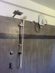 a shower in a bathroom with a microphone on the wall at Viska Villa 2 Bedroom Home 5 min to Hiriketiya in Nilwella