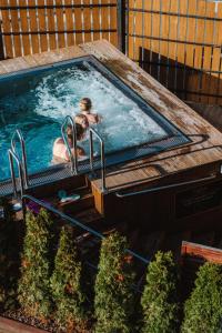 a man in a jacuzzi in a swimming pool at ZAKOZNAMI-WILLA WYPOCYNEK SPA in Zakopane
