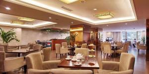 成都市にあるChengdu Sovereign Hotelの部屋にテーブルと椅子があるレストラン