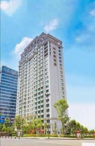 成都市にあるChengdu Sovereign Hotelの前に木々がある背の高い白い建物