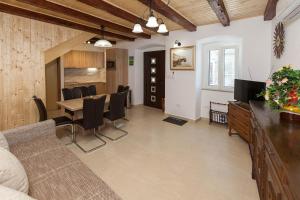 a living room and dining room with a table and chairs at Holiday Home NiKa in Omišalj