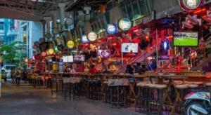 a restaurant with tables and chairs and lights at Elegancy Sansabai Hotel in Patong Beach