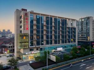 un grand bâtiment avec de nombreuses fenêtres donnant sur une rue de la ville dans l'établissement Jinjiang Inn Changzhou Global Dinosaur City Olympic Center, à Changzhou