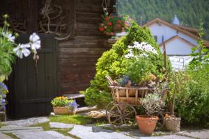 un jardín con flores y plantas frente a una casa en Hotel Romantica en Zermatt