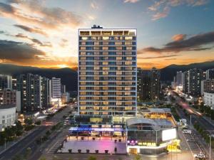 a tall building in a city at night at FOGER YACHT HOTEL in Pingshanongchang
