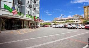 un parking avec des voitures garées devant les bâtiments dans l'établissement Vatica Beijing Miyun West Guoyuan Street Hotel, à Xiaotangzhuang