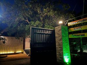 a gate in front of a fence at night at Cashew Garden Resort & Restaurant in Dambulla